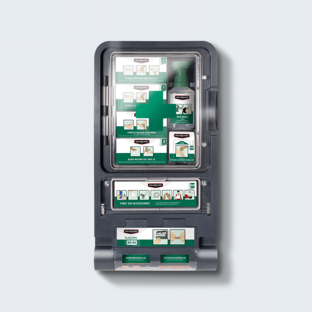 Førstehjælpsstation med udstyr til sårbehandling og øjenskyl, designet til arbejdspladser med fokus på overblik og effektiv første indsats. Stationen har tydeligt placerede refills, synlig datomærkning og kan genopfyldes uden værktøj, hvilket gør vedligeholdelsen enkel. Førstehjælpsstation